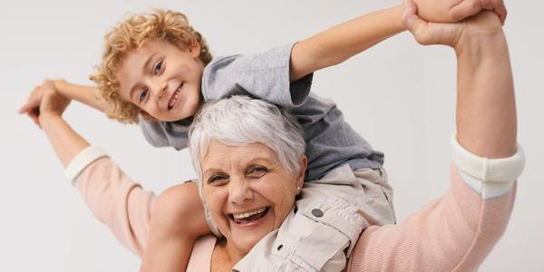 Señora mayor con su nieto subido a los hombros