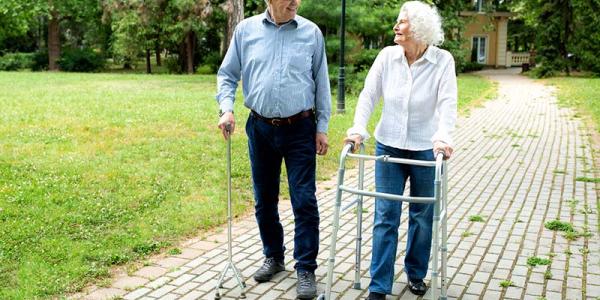Una pareja de personas mayores camina por un parque