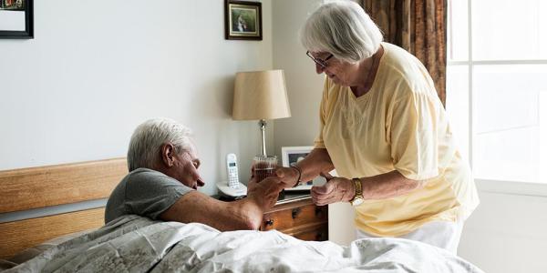 Una cuidadora ayudando a una persona mayor 
