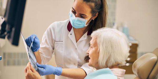 Una mujer mayor es atendida por una odontóloga en la consulta
