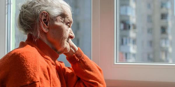 Una mujer mira mira a través de una ventana