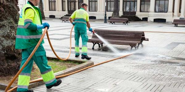 Dos operarios de la limpieza trabajan en la calle.