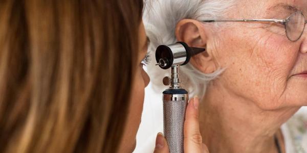 Una persona mayor en una consulta de revisión auditiva 