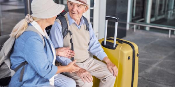 Dos ancianos de viaje con las maletas