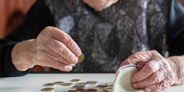 Manos de una persona mayor contando monedas